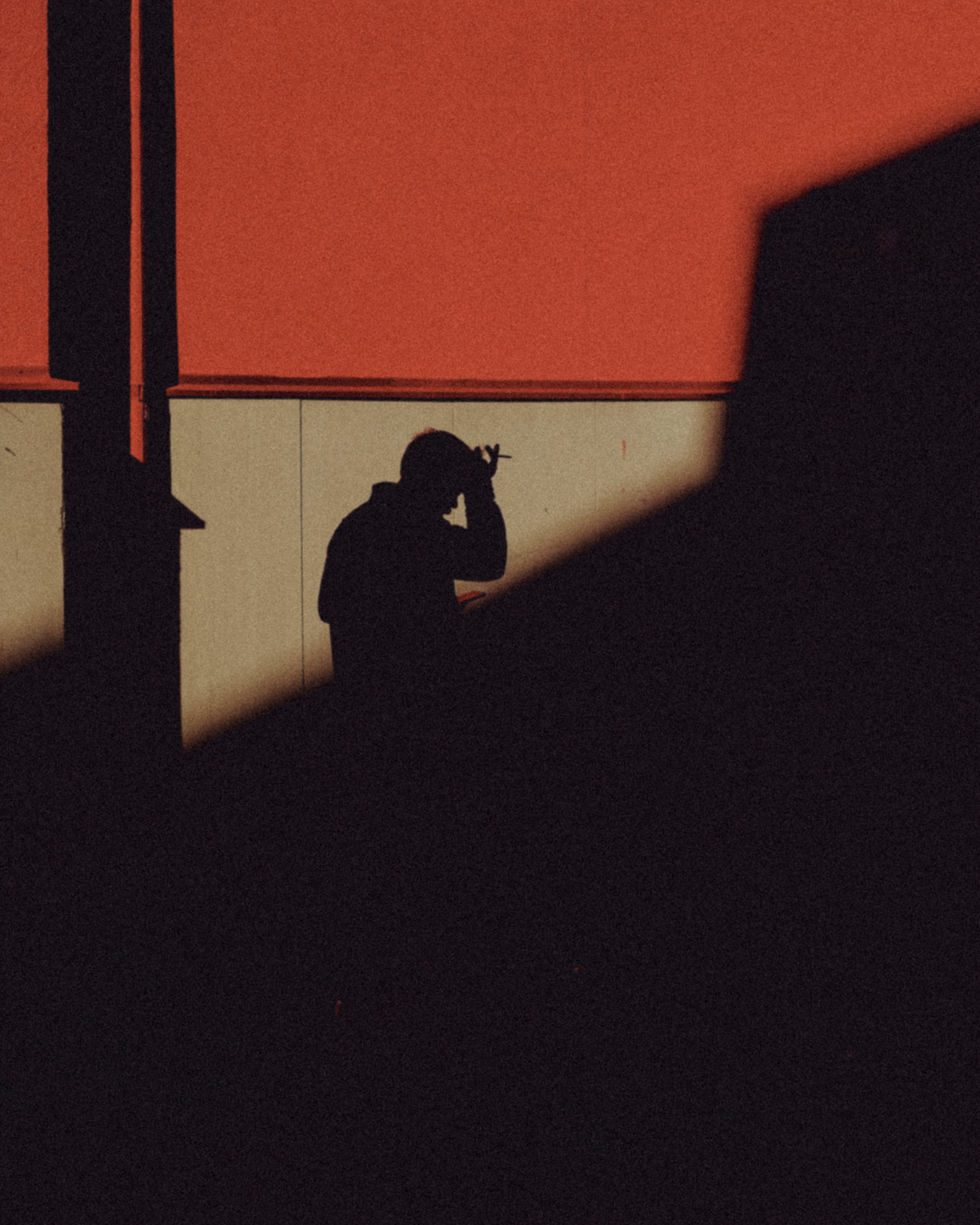 Photographer's shadow on a sunlit red wall