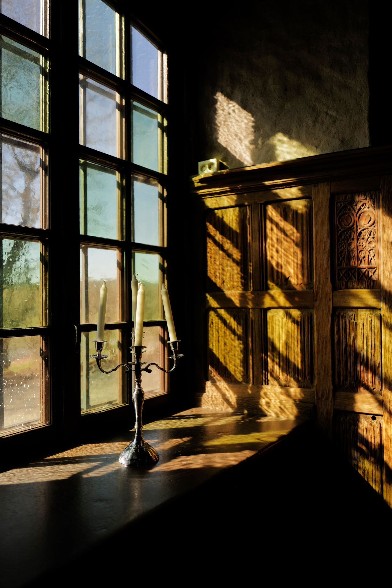 Silver candelabra on a windowsill in warm afternoon light
